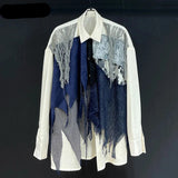 White shirt with blue and patterned design on a black background