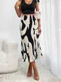 Person wearing a black and white patterned skirt in a minimalistic room.