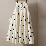 White skirt with black polka dots on a hanger against a beige background, branded 'JoinYouth'.