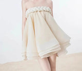 Woman wearing a strapless dress with a braided detail on a white background, featuring the brand 'TWTWINSTYLE'.