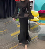 A turquoise two-piece outfit with puff sleeves and ruffles, consisting of a shirt and a matching skirt, displayed on a hanger.