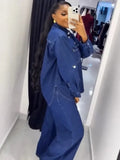 Person wearing a blue denim outfit taking a mirror selfie.
