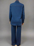 Blue denim shirt and pants set on a mannequin against a white curtain background