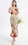 Woman wearing a floral dress holding flowers on a white background