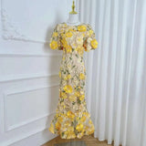 Yellow floral dress on a mannequin against a white curtain background