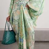 Person wearing a green floral dress holding a green woven handbag against a neutral background