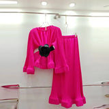 A turquoise two-piece outfit with puff sleeves and ruffles, consisting of a shirt and a matching skirt, displayed on a hanger.