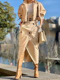 Person wearing a beige trench coat and high-heeled boots with a blurred background