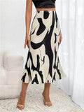 Person wearing a black and white patterned skirt in a minimalistic room.